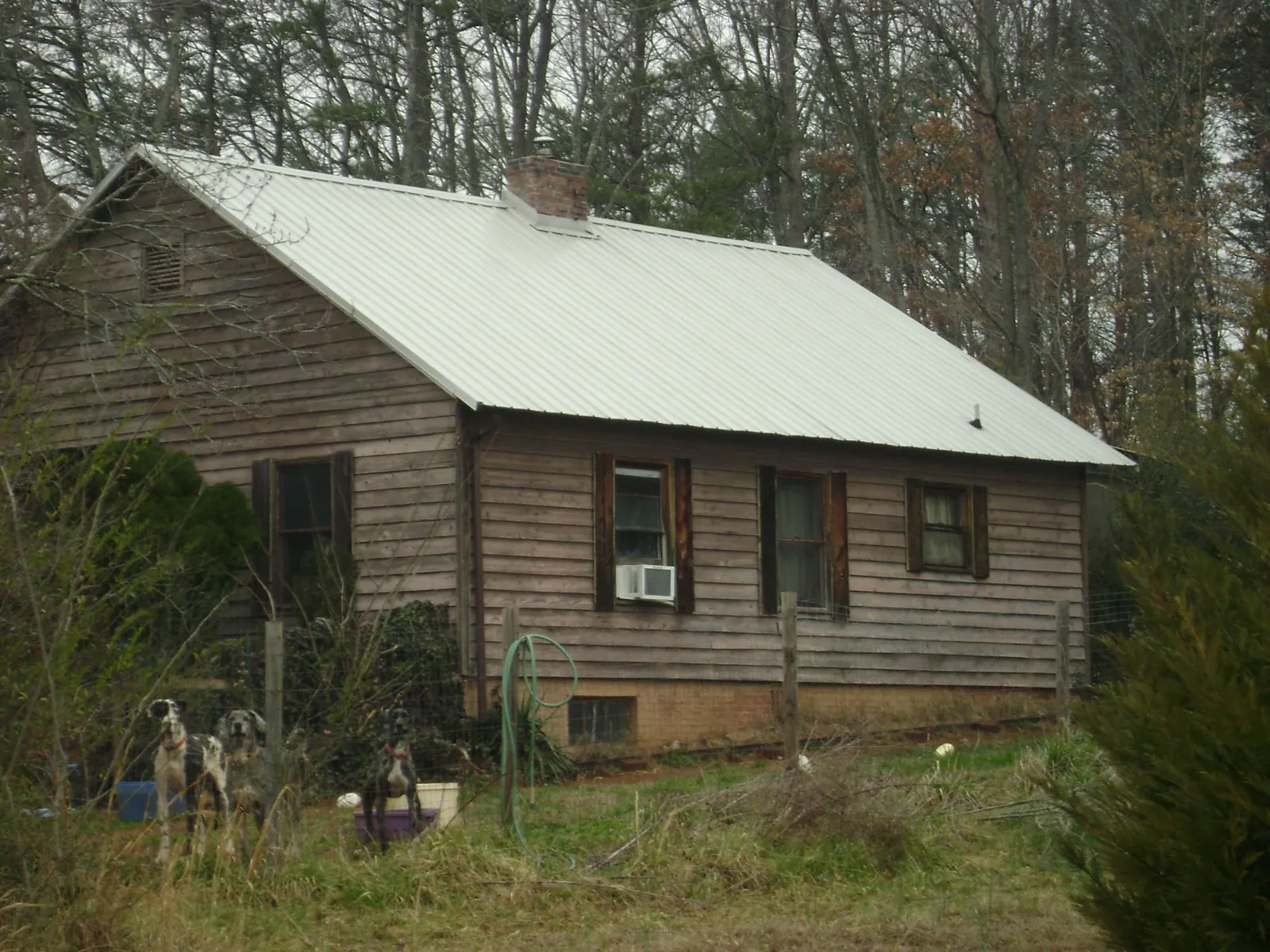 White metal roof on an old wood sided farmhouse, from a Metal Roof Installation job in Mayodan